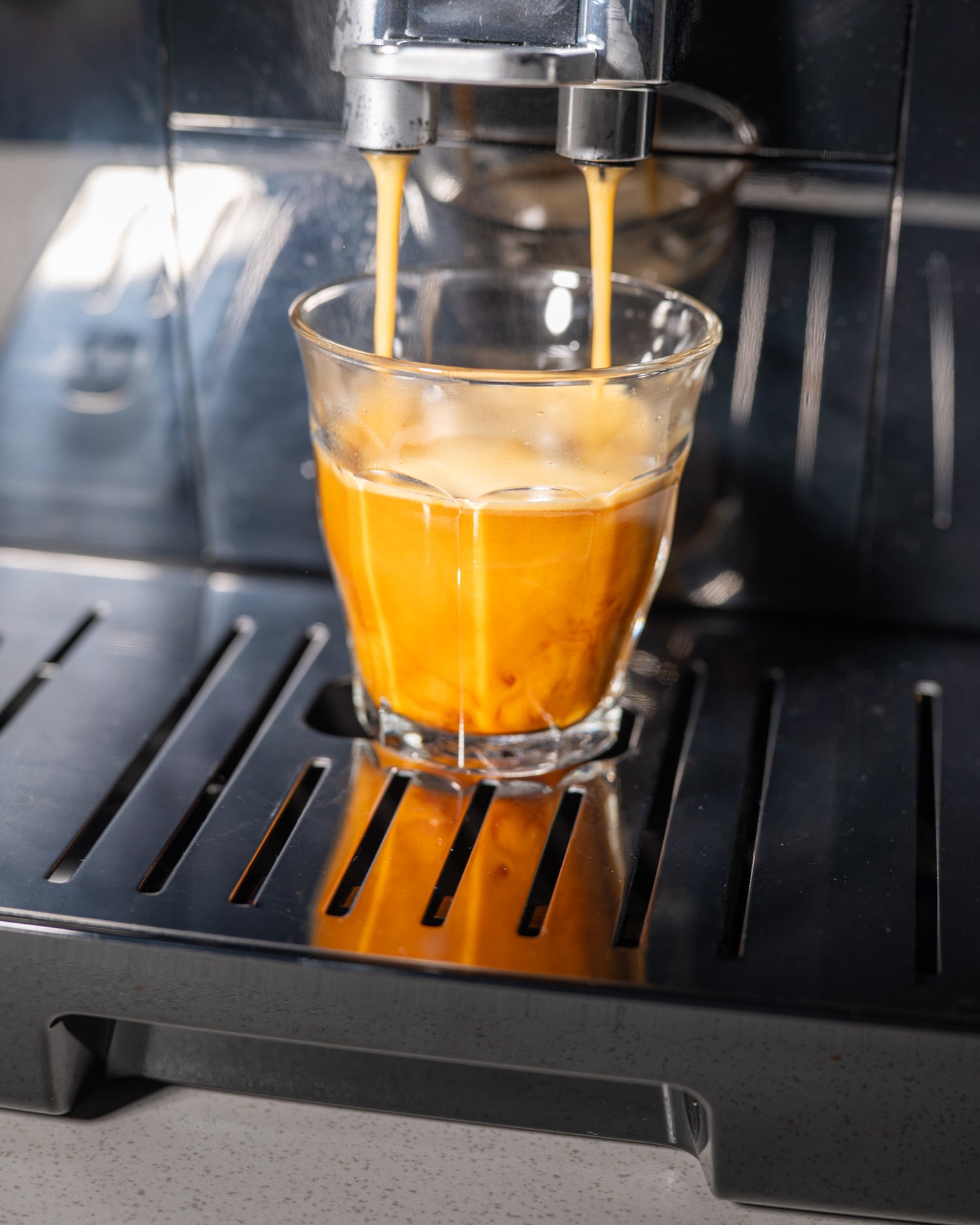 café qui coule en espresso dans une tasse depuis une machine dinamica de delonghi