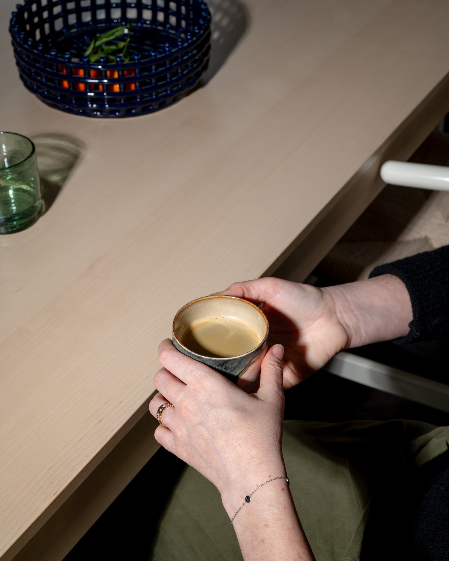 personne tenant une tasse d'espresso manifeste assise à un table