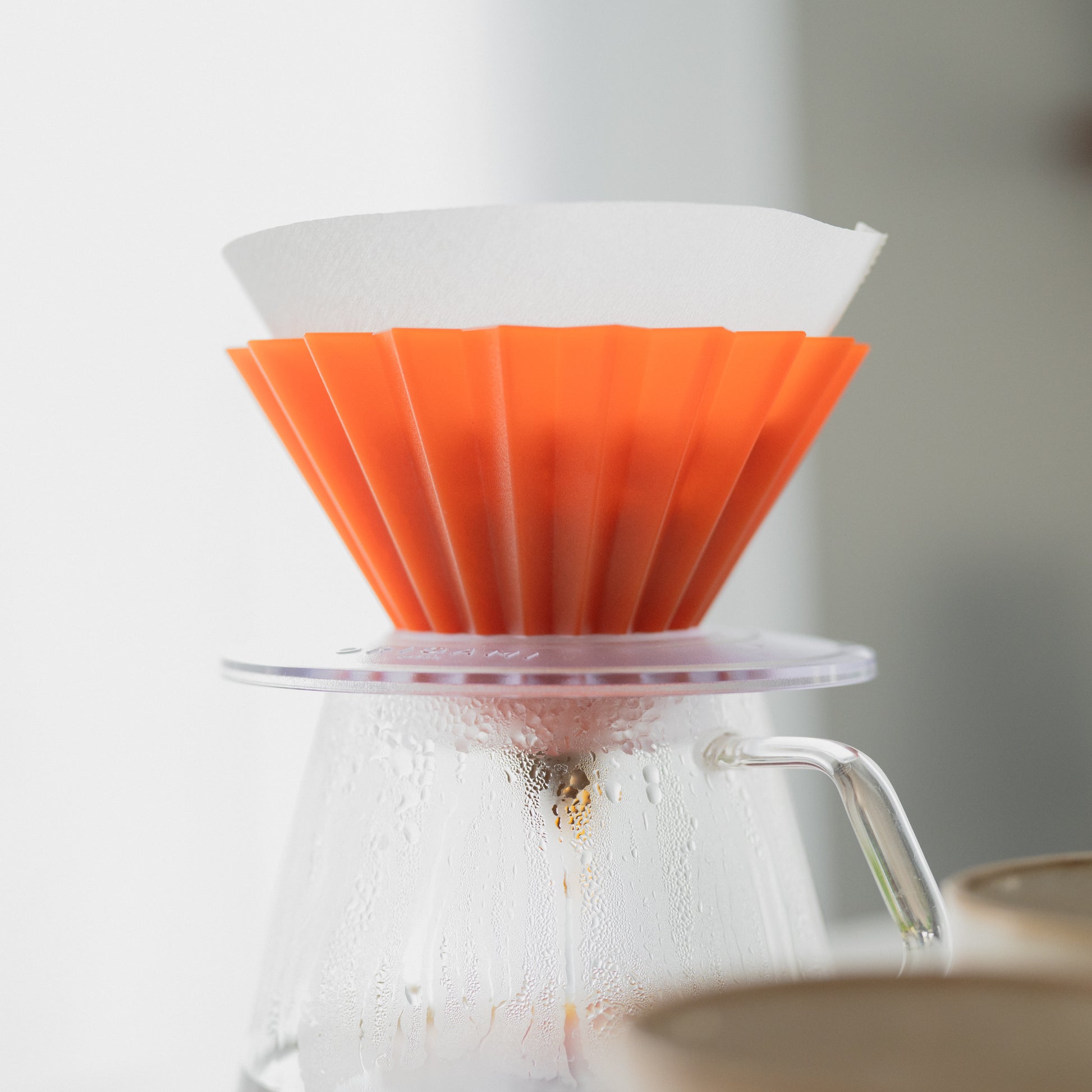 café filtre qui coule dans un origami et une carafe kinto en verre 
